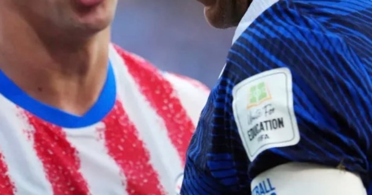 Kylian Mbappé sur un terrain de football, affichant un sourire calme face à l'adversité
