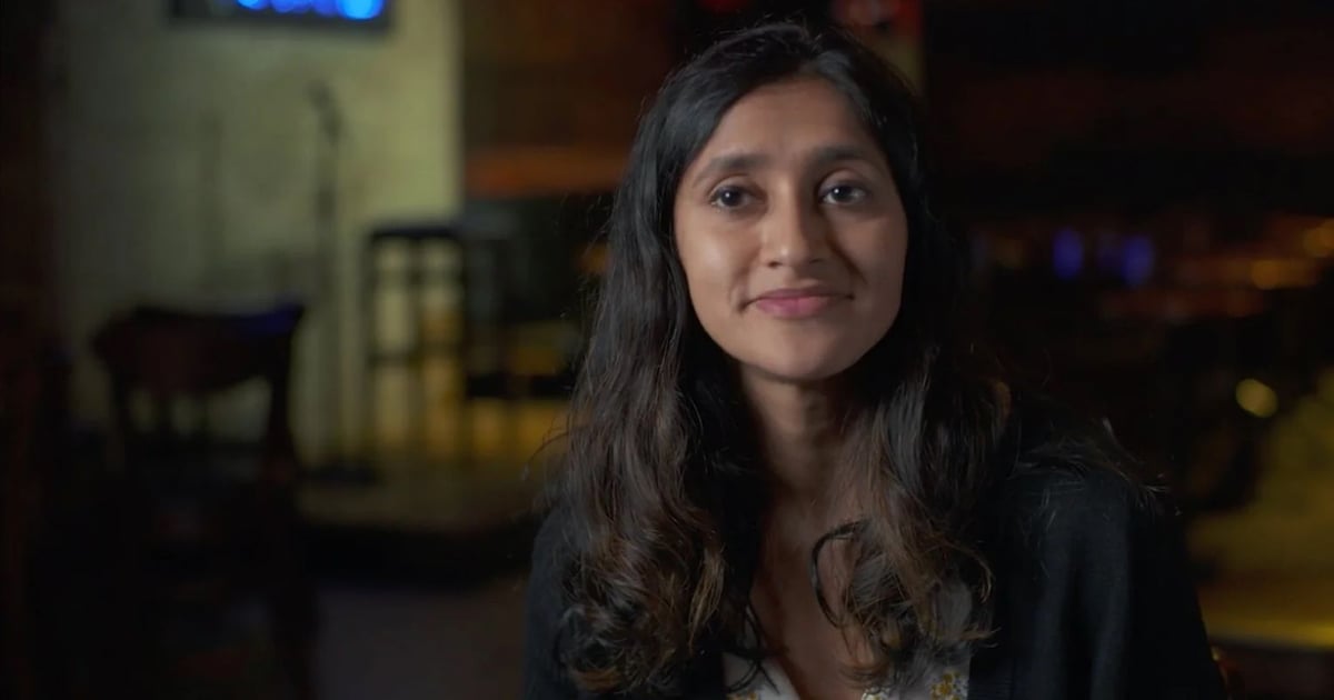 Portrait d'une personne souriante tenant un micro, symbolisant la transformation de l’anxiété en créativité sur scène