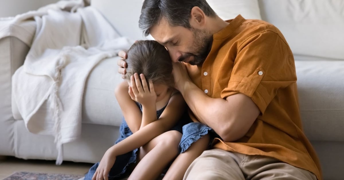 Parent réconfortant un enfant en pleine tempête émotionnelle dans un cadre apaisant