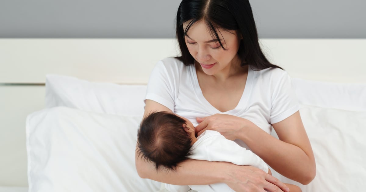 Maman berçant son bébé endormi dans une lumière douce, symbole de sommeil paisible