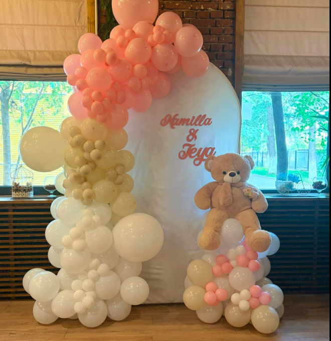 Arcadă albă personalizată cu ghirlandă de baloane roz, nude, albe și un ursuleț maro de pluș