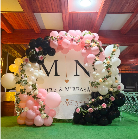 Photocorner rotund pentru nuntă cu baloane roz, albe, negre și inserții florale