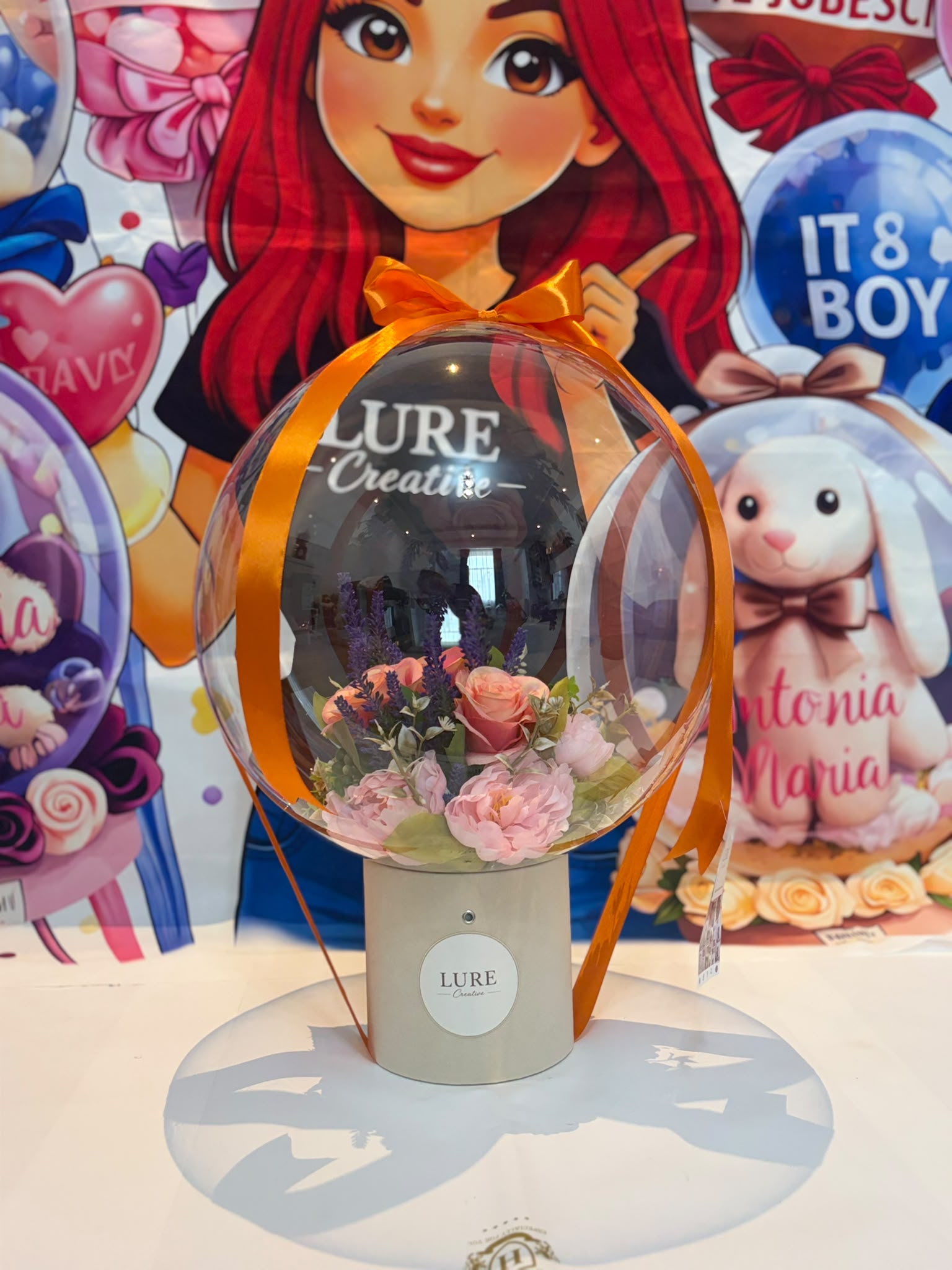 BoBo balon transparent cu flori roz si levantica in interior legat cu panglica portocalie