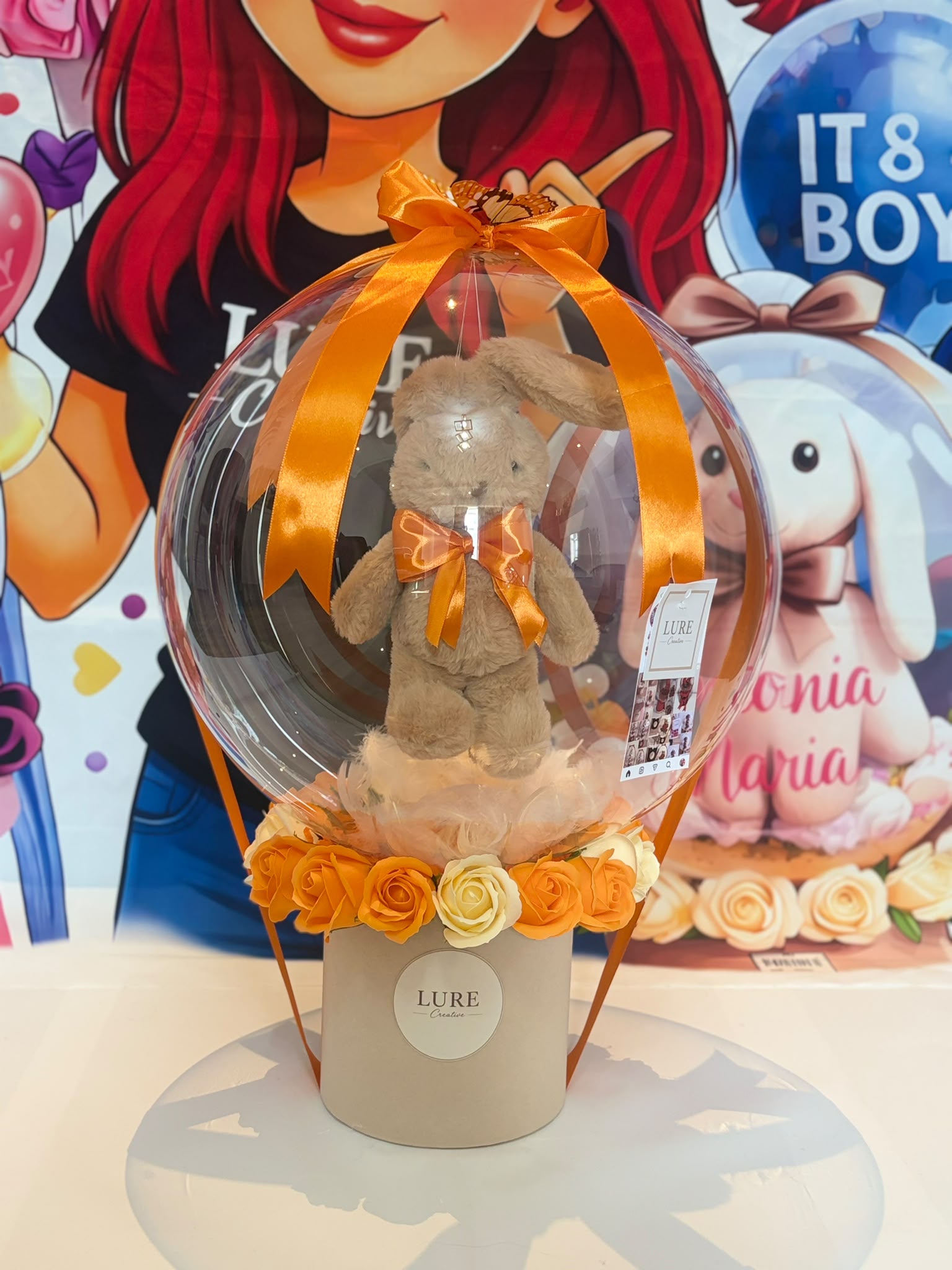 BoBo balon transparent cu iepuraș de pluș maro și flori portocalii în cutie bej