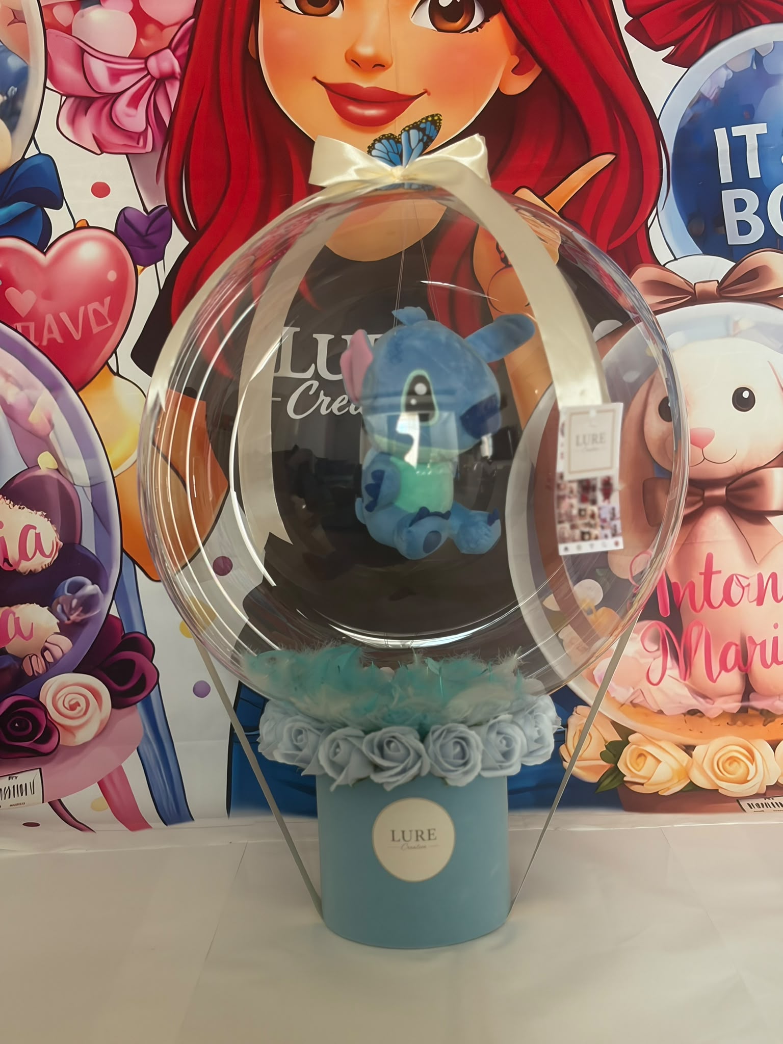 Balon BoBo transparent cu plus albastru Stitch intr-o cutie cu trandafiri