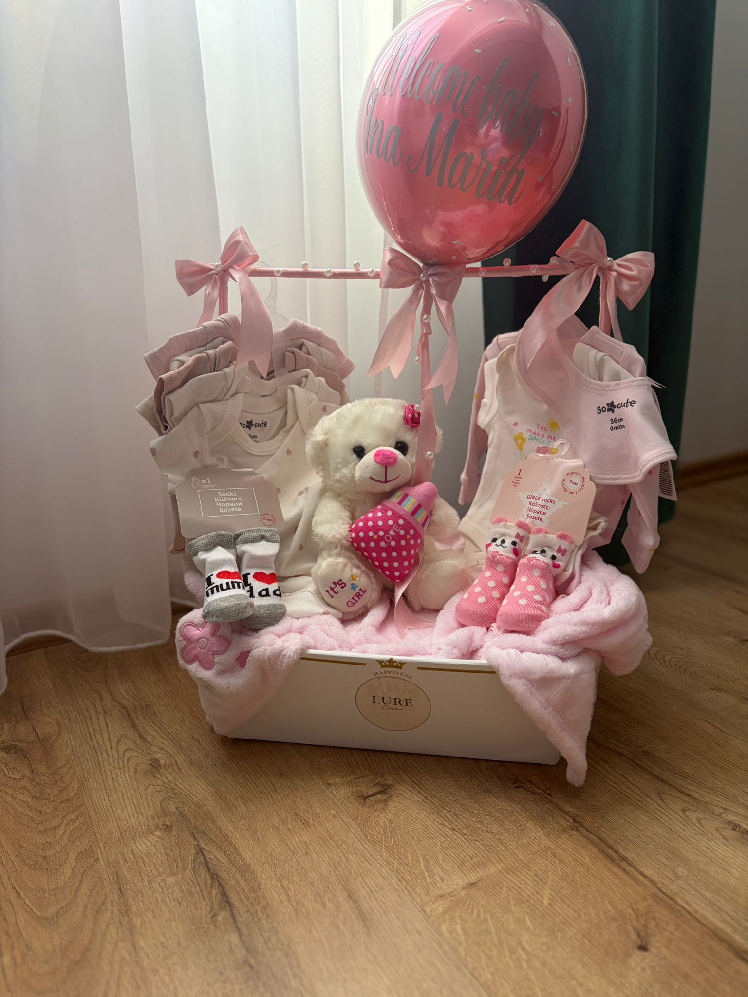 Coș cadou roz cu hăinuțe pentru bebeluși, ursuleț și balon personalizat