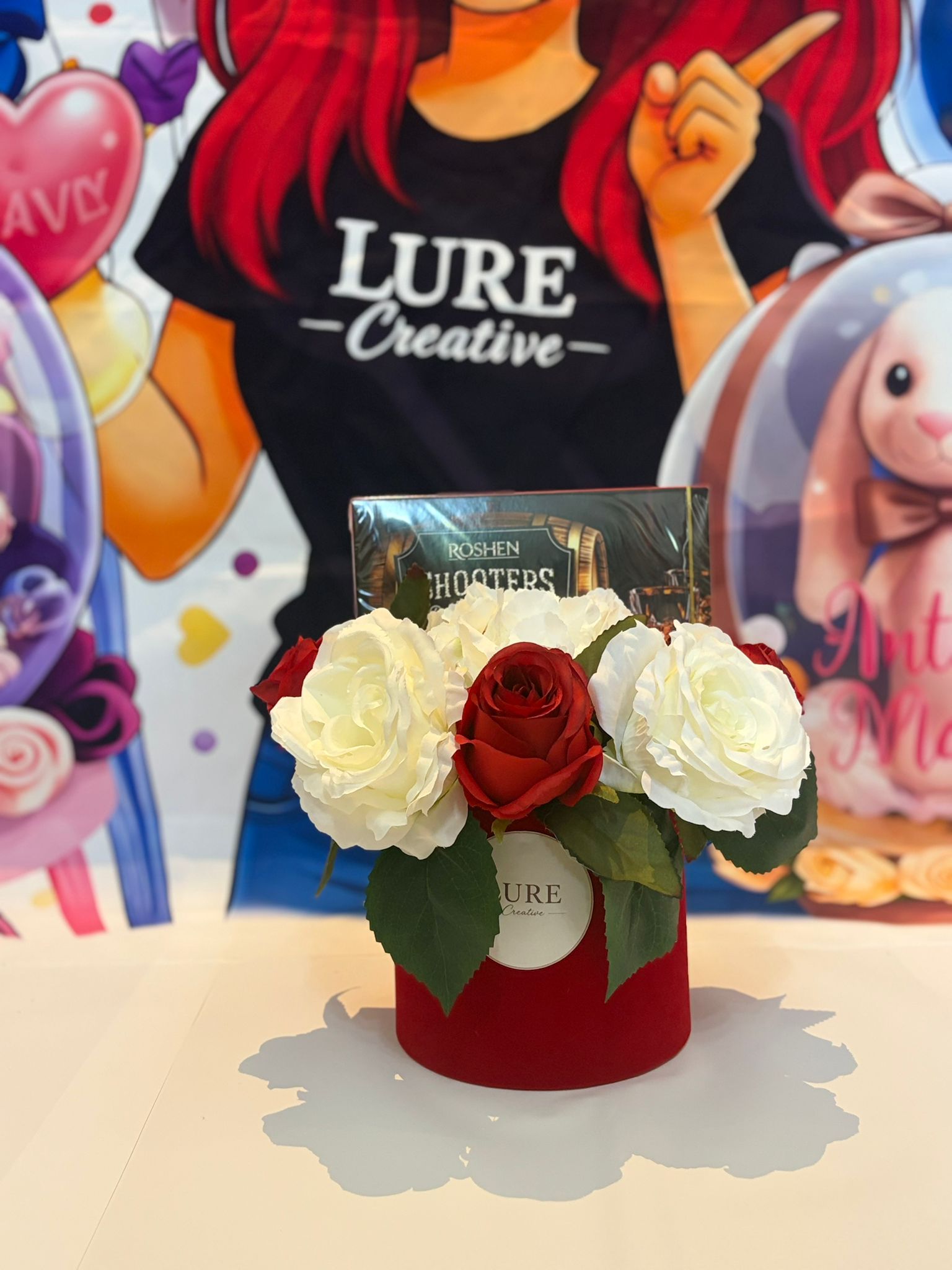 Aranjament floral cu trandafiri albi si rosii in cutie rosie cu bomboane de ciocolata