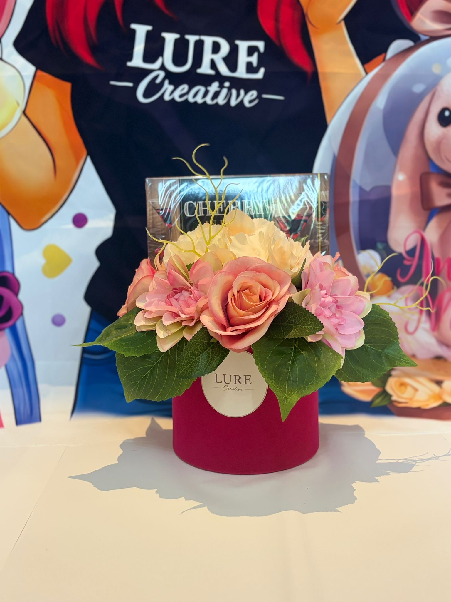 Aranjament floral cu trandafiri roz si praline in cutie catifelata magenta