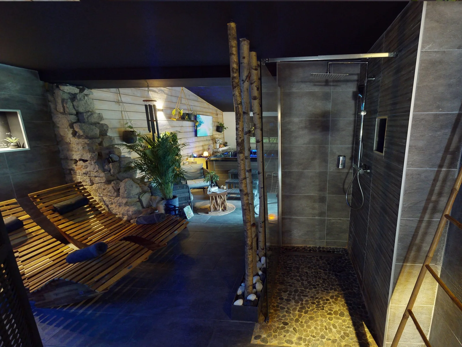 Sauna privatif en bois éclairé en bleu dans une suite romantique
