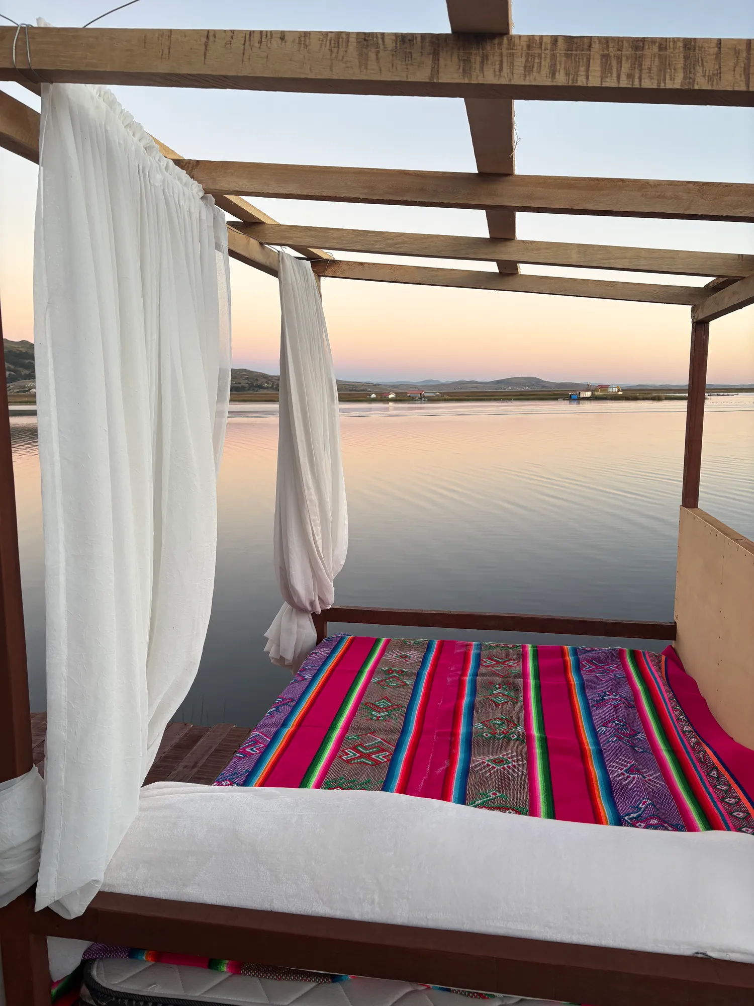 Canopy bed facing the lake at dawn