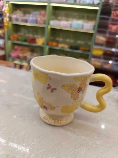 مج بتصميم فراشة مصنوع يدويًا