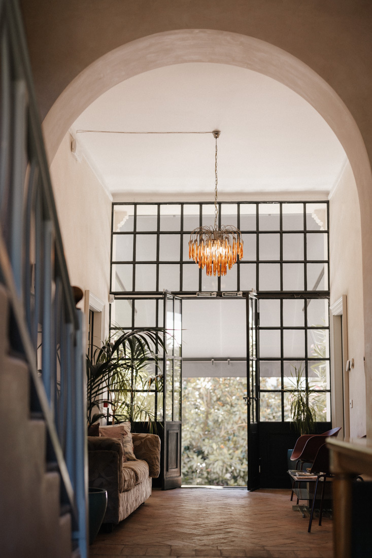 Raum mit Bogen Lampe Fenster und Treppe mit Pflanzen und Möbeln
