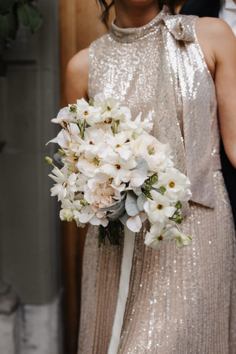 Eleganter Hochzeitsstrauß aus weißen Blumen und frischem Grün in klassischer Bindung