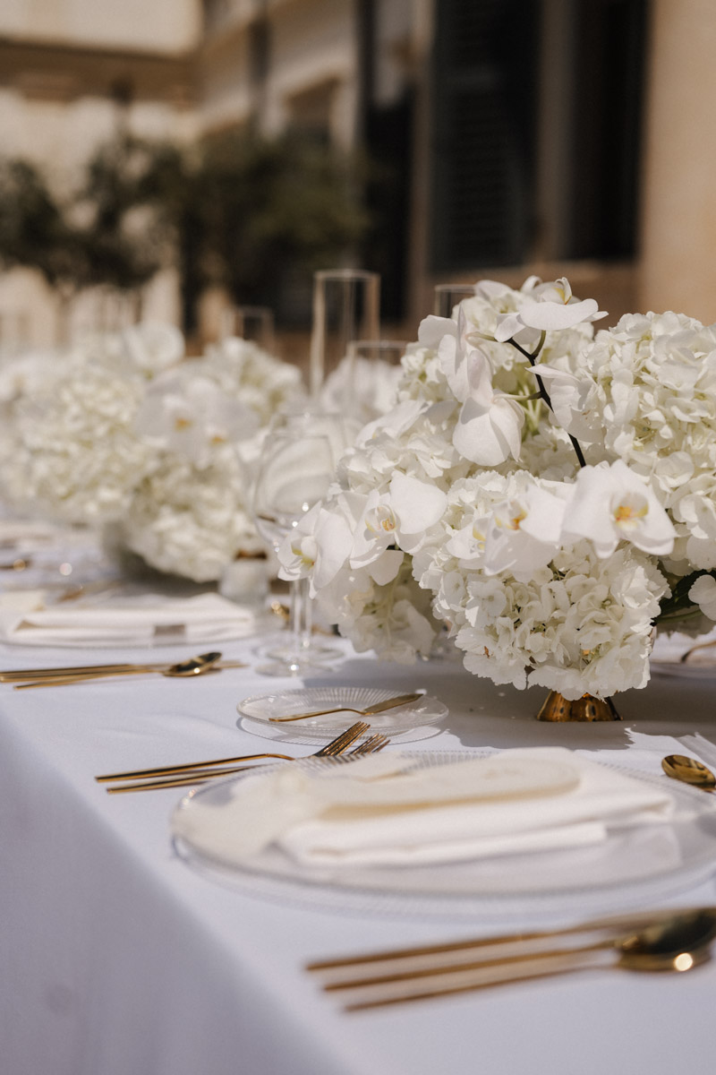 Festlich gedeckte Hochzeitstafel mit weißen Orchideen und goldenen Akzenten