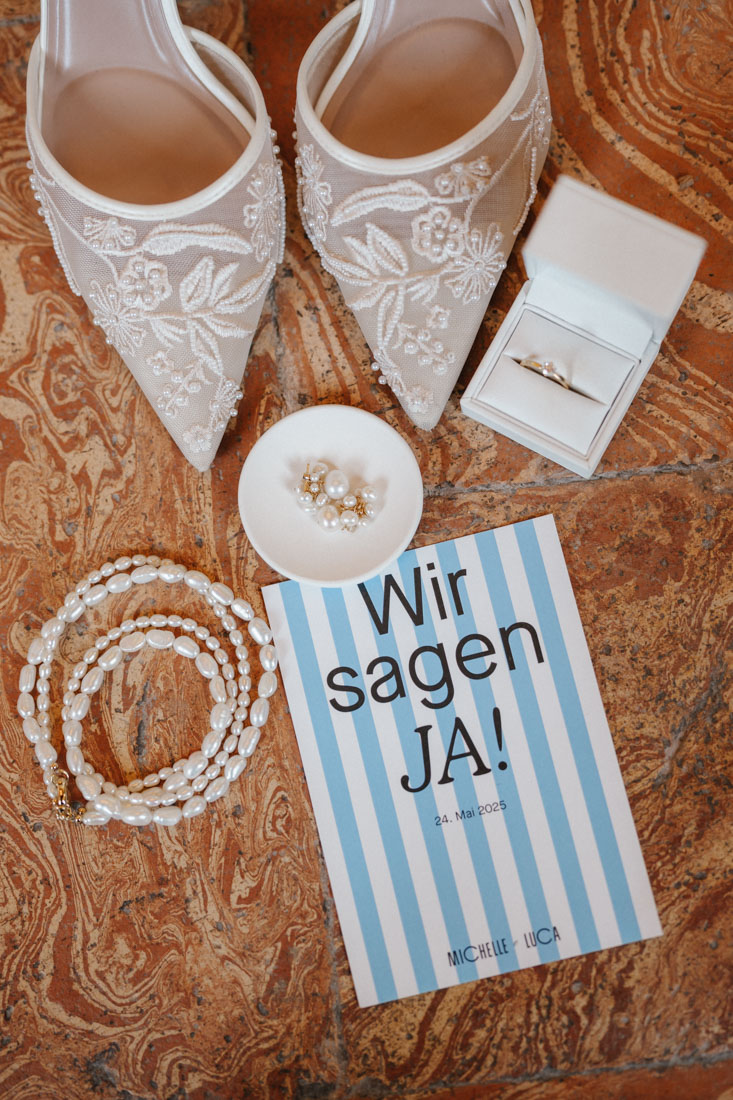Schuhe mit Spitze und Perlen mit Schmuck und Ring bei Einladung