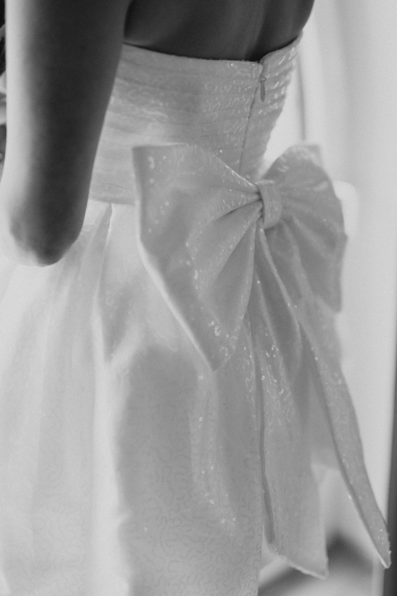 Detailaufnahme weisses Kleid mit grosser Schleife und Reissverschluss