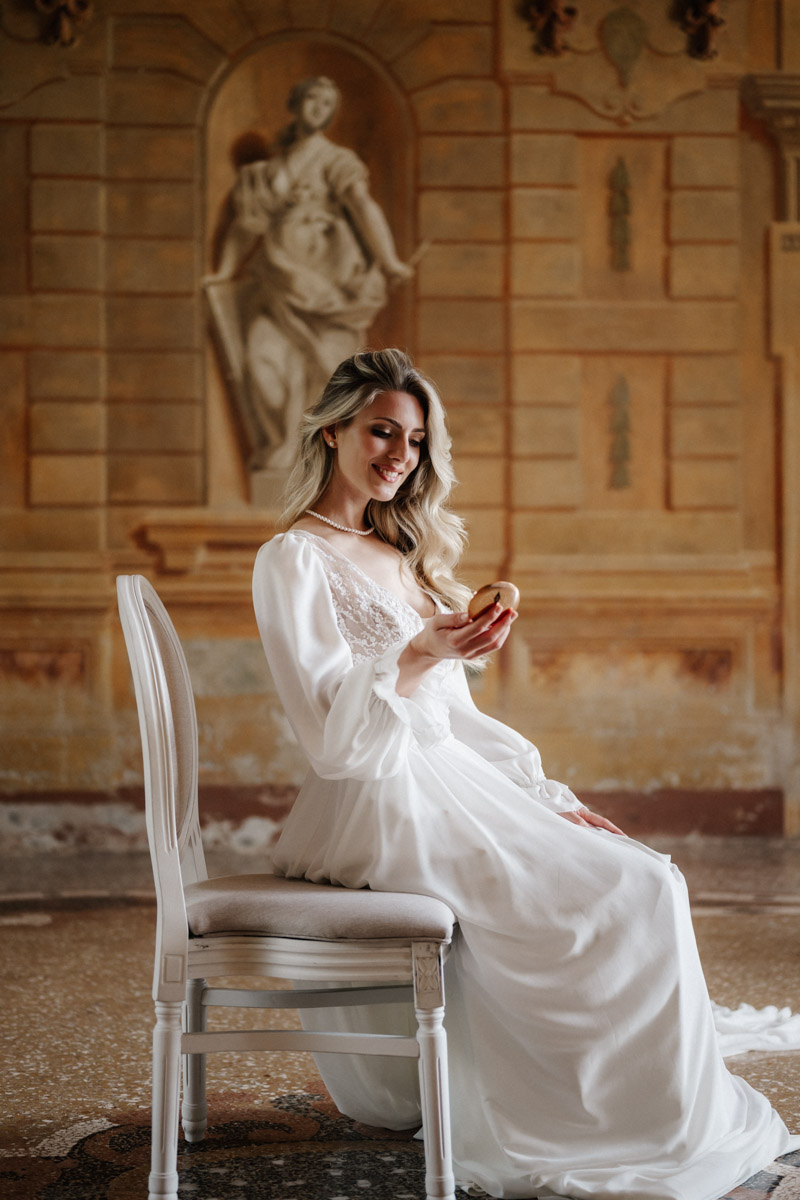 Elegantes Brautporträt in luxuriösem Hochzeitskleid vor historischer italienischer Villa