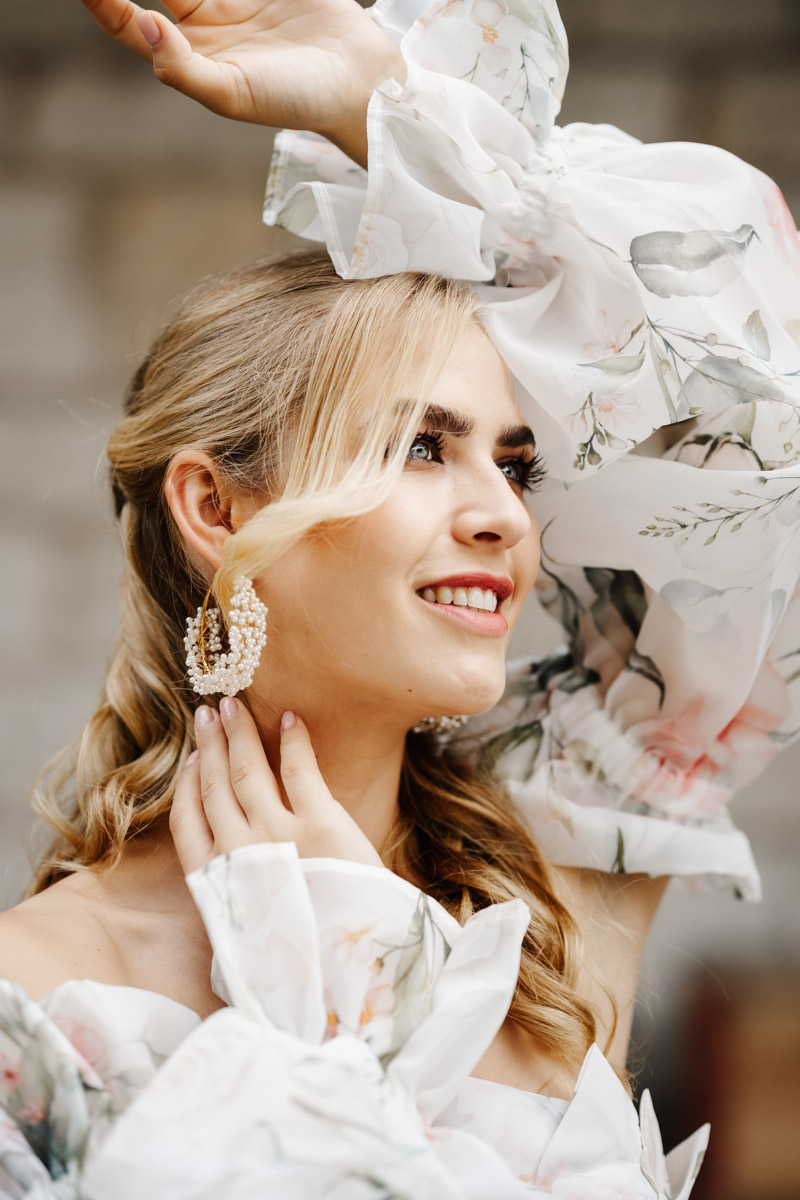 Braut mit sanftem Lächeln in elegantem Hochzeitskleid mit floralen Details