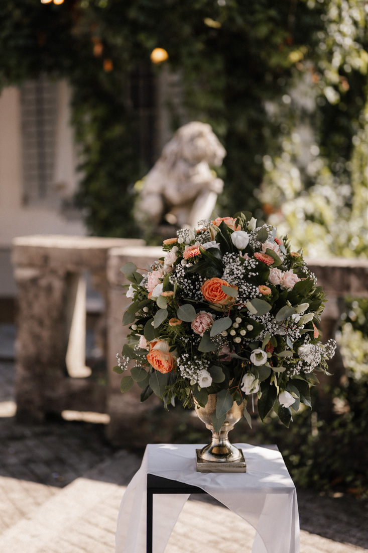 Blumenarrangement mit Rosen und Schleierkraut in goldener Vase