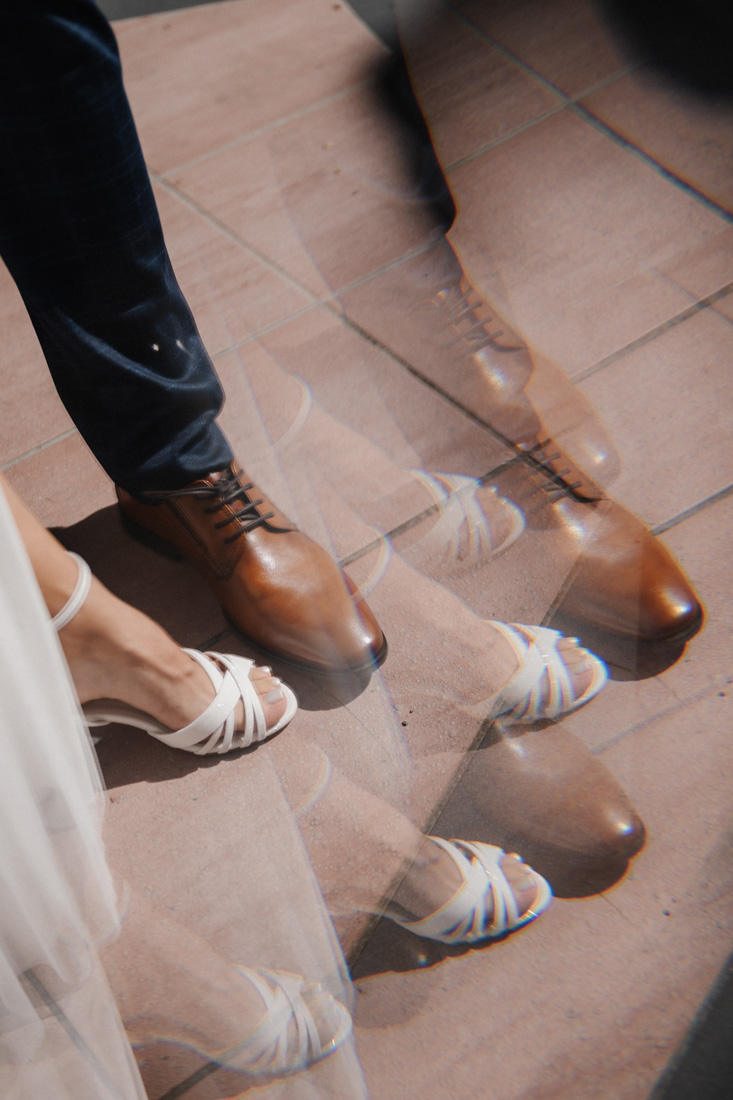 Brautschuh und Herrenschuh auf Fliesen mit weissem Kleid