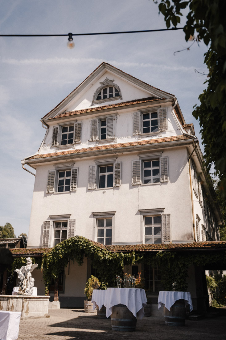 Fass Tische mit weisser Decke vor weissem Gebäude mit Fensterläden
