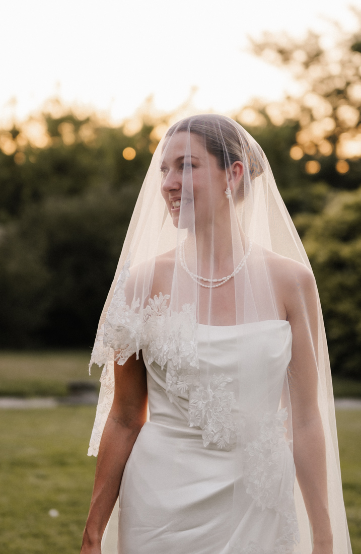 Frau mit Schleier und Kleid mit Spitze sowie Kette und Ohrringe
