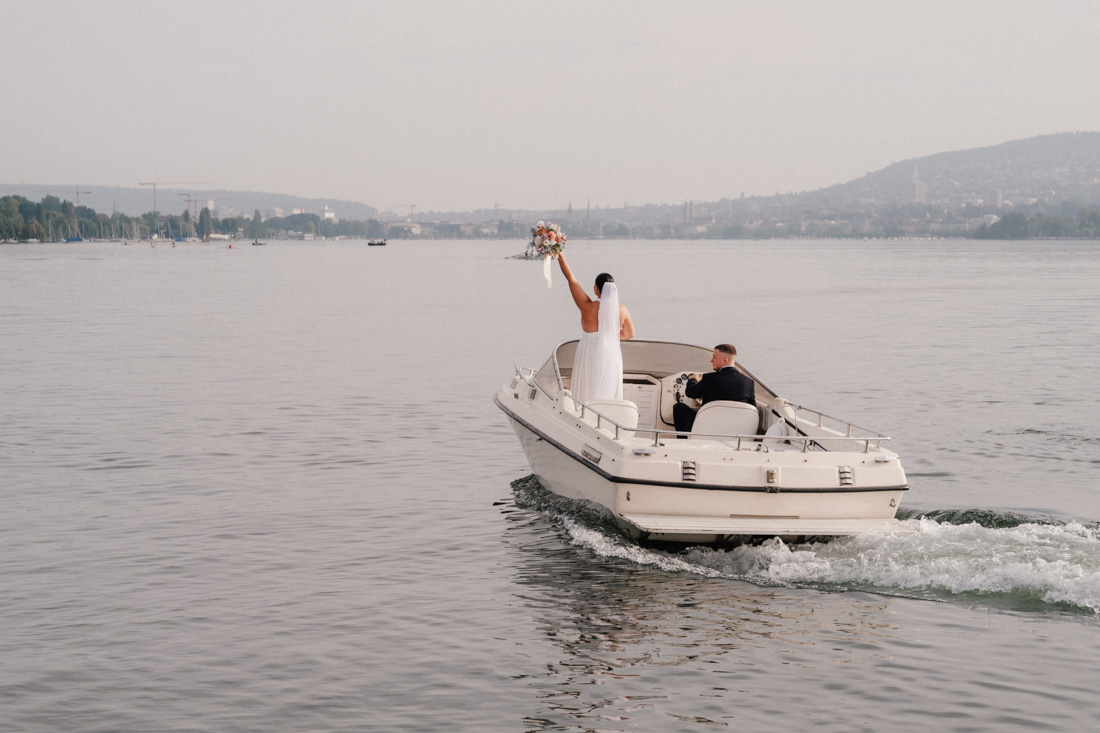 Frau mit Brautstrauss und Mann auf Motorboot auf dem See