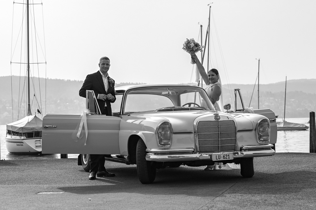 Brautpaar mit Oldtimer Mercedes am See und Booten im Hintergrund