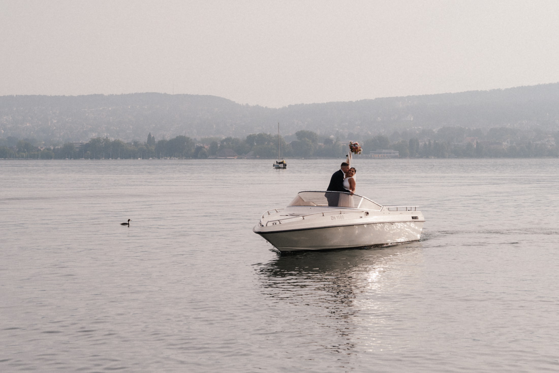 Paar auf Motorboot mit Blumenstrauss auf Zürisee mit Bergen