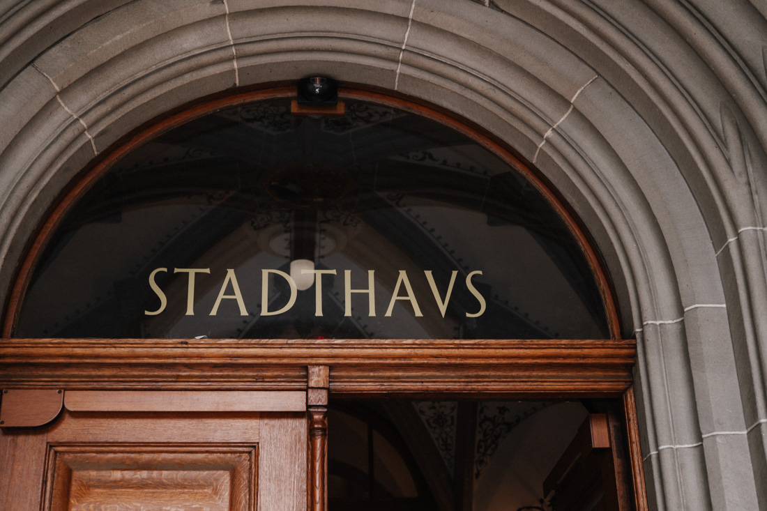 Stadthaus Schriftzug über Holztür unter einem Steinbogen