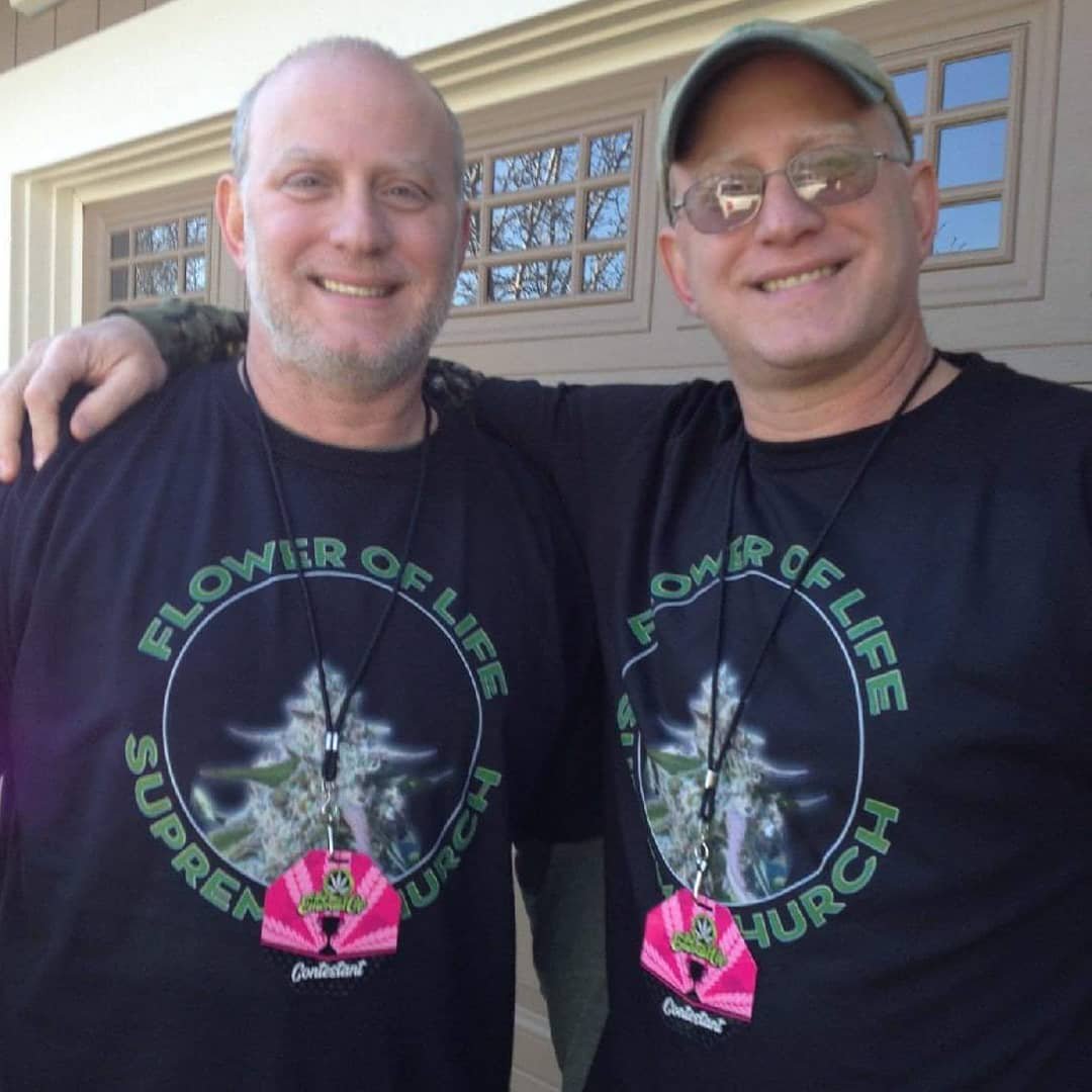Two people smiling together in matching Martyjuana Flower of Life shirts