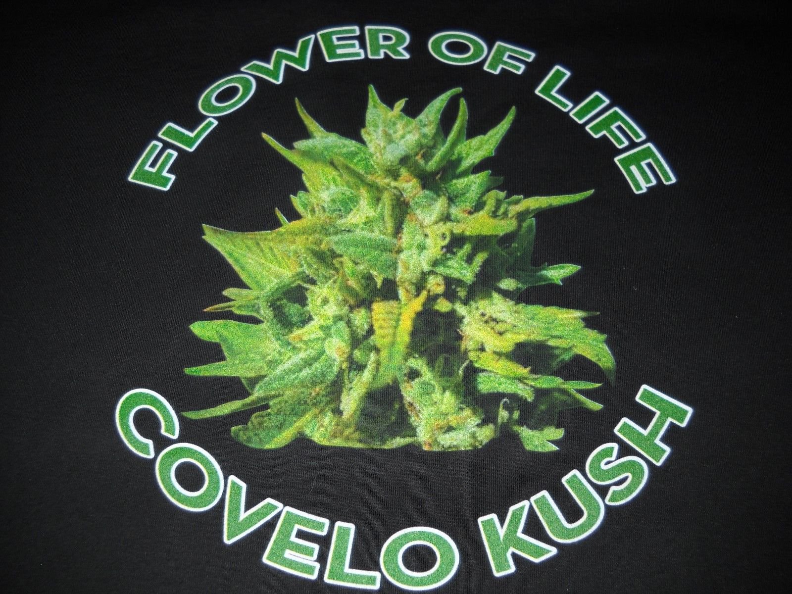 Flower of Life and Covelo Kush lettering around a cannabis flower on black