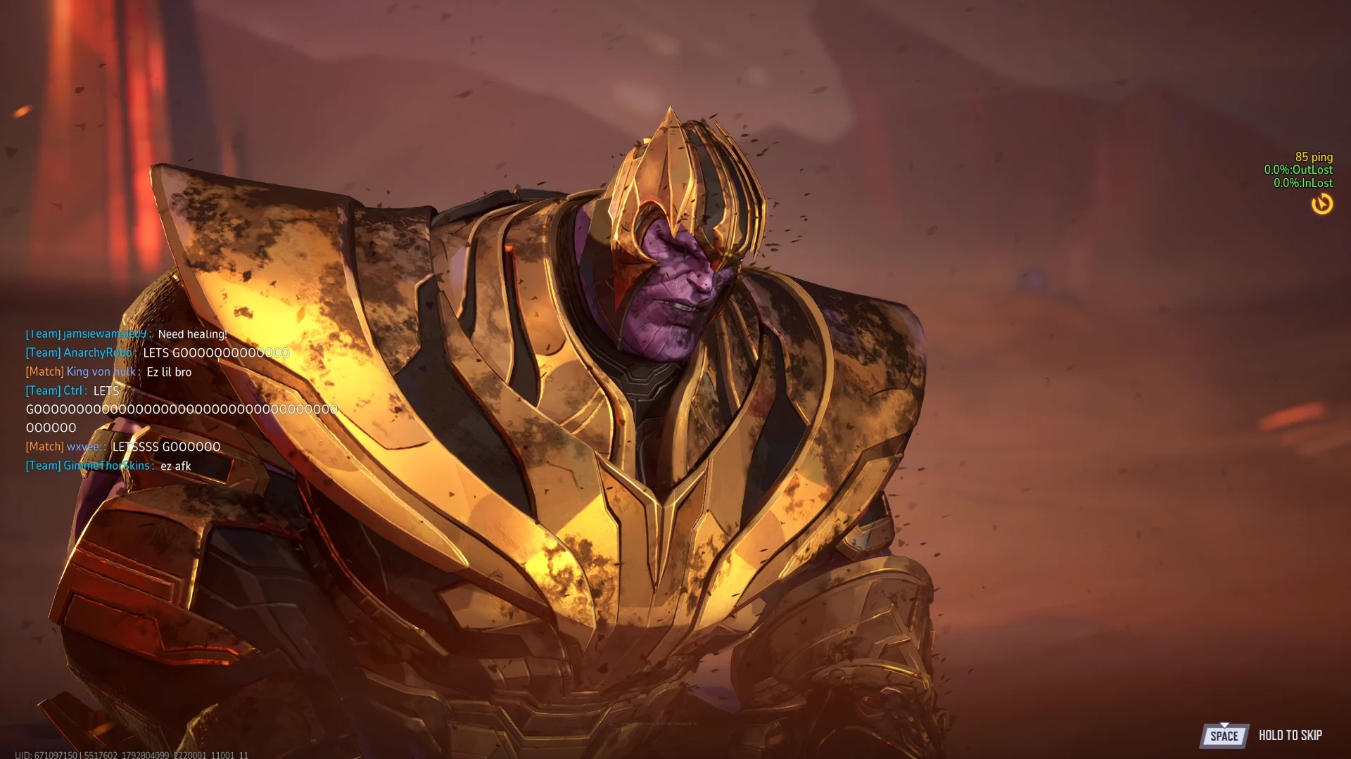 Cinemática do final: Thanos derrotado, em close, com a armadura dourada desgastada e poeira no ar, e o chat da equipe comemorando à esquerda