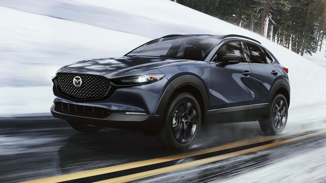 Vue 3/4 avant et latérale du Mazda MX-30 2025 sur route de neige en pleine puissance