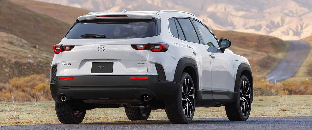 Vue arrière d'une Mazda CX-50 2025 Hybride en arrêt sur chemin de terre