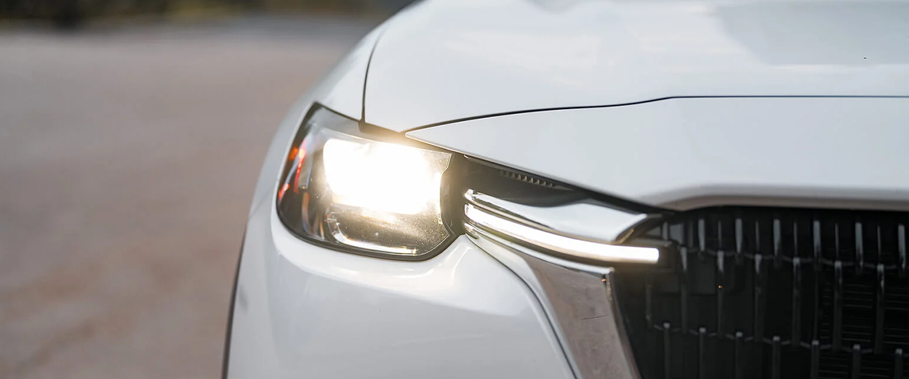 Vue avant de près d'une Mazda Hybride 2025 avec phare allumé