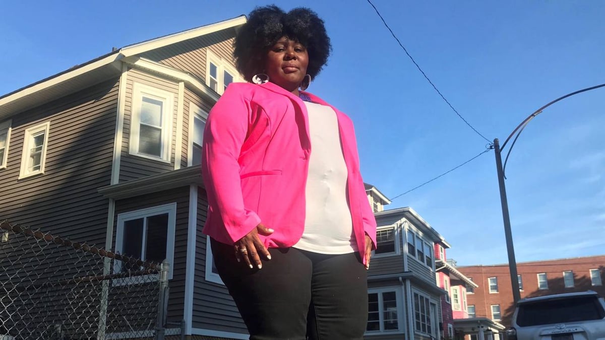Latoya Gayle in bright pink blazer in neighborhood setting