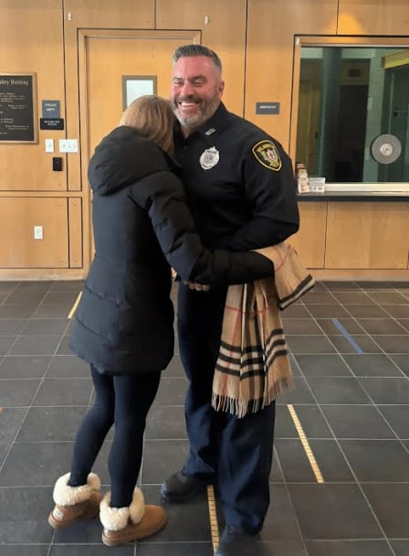 The woman hugs Detective Ceruolo at the Wilmington police station after getting her scarf back
