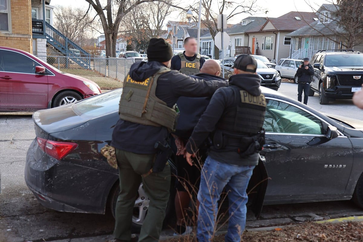 ICE officers detaining a man on a residential street