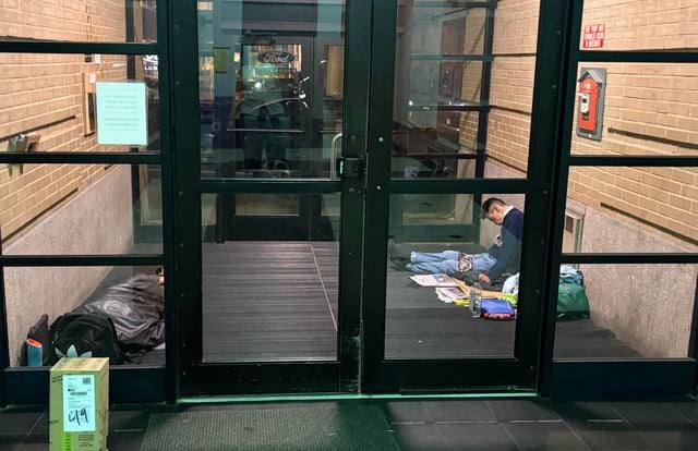 Two homeless men sleeping inside the foyer at 61 Brookline Ave