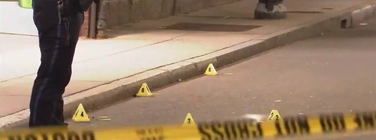 Evidence markers scattered across Friend Street under police tape.