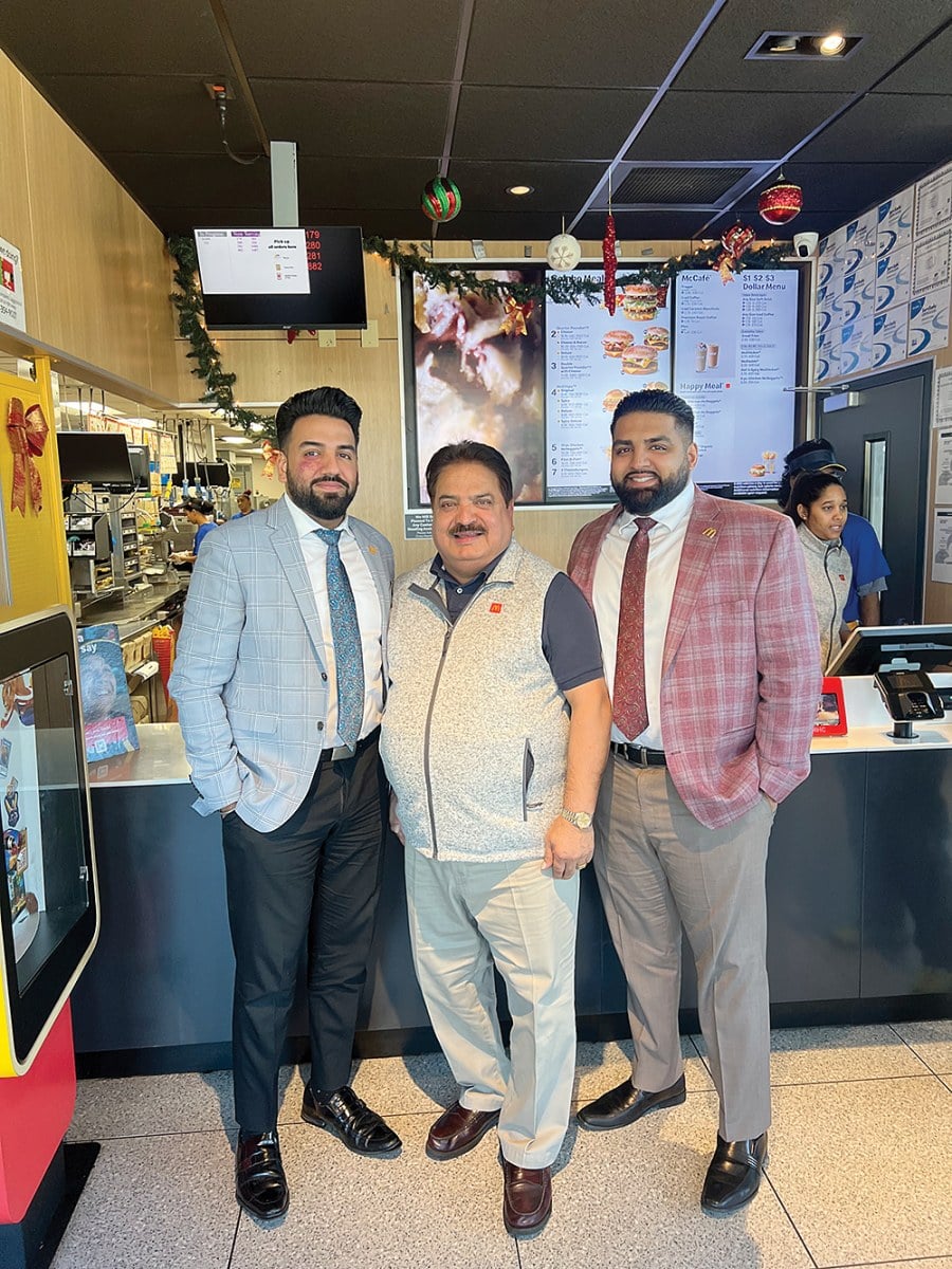 Vijay Selhi with his sons Cherag and Anurag, co-owners of 19 Boston McDonald's franchises.