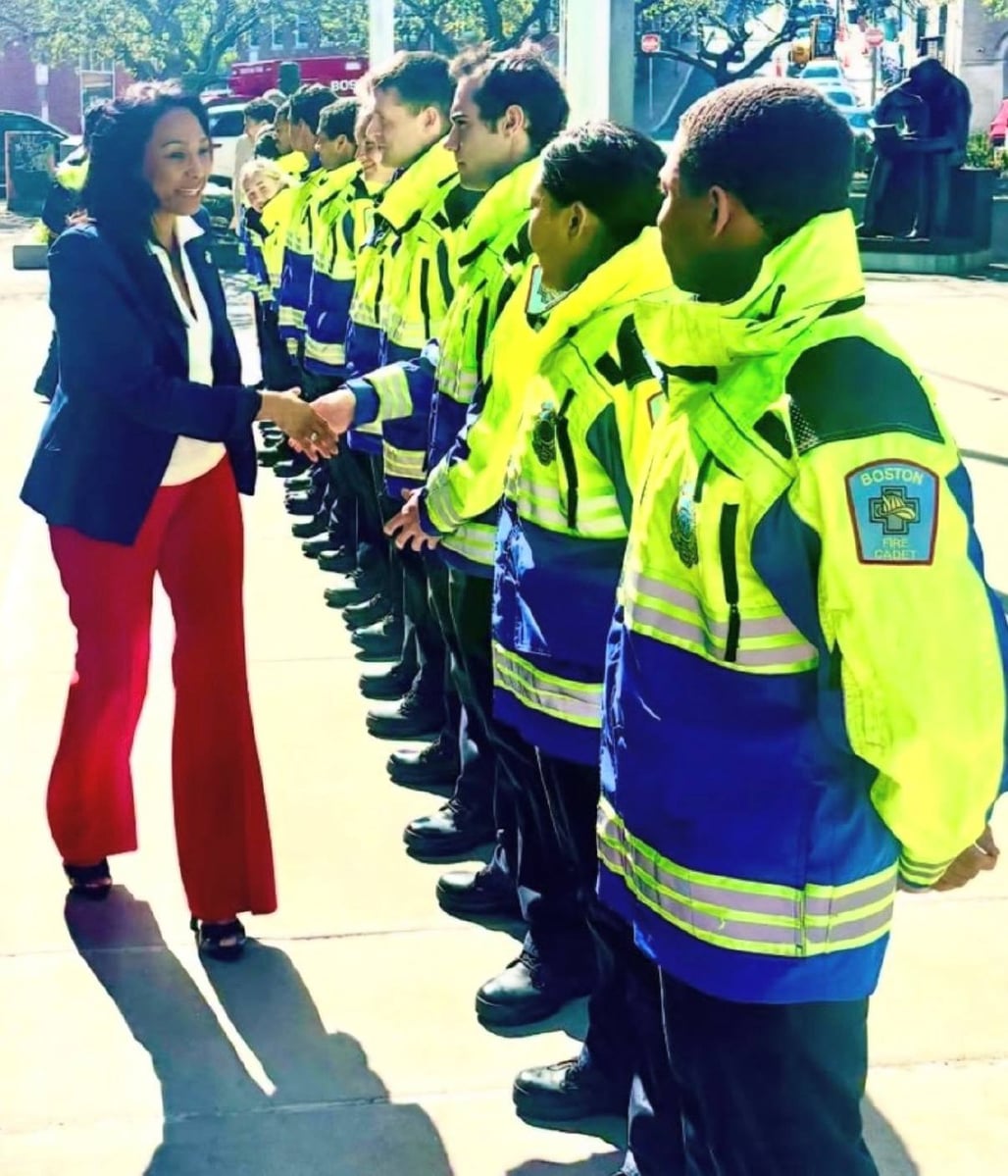Linda Champion greets a line of Boston EMS personnel.