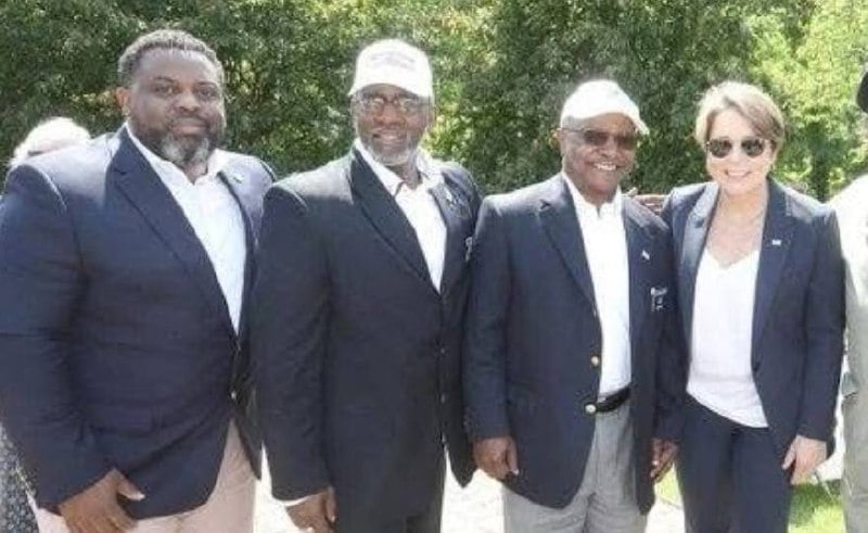 LaMar Cook standing with Gov. Maura Healey at an outdoor event.