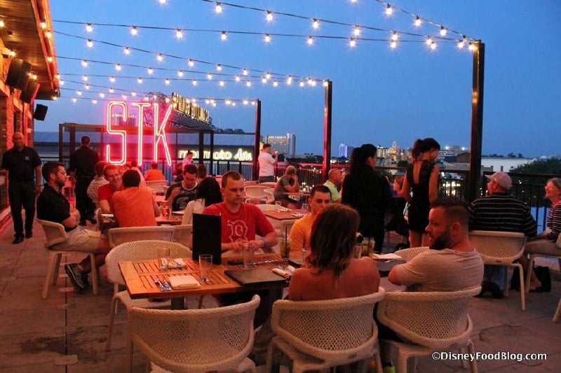 STK Disney Springs rooftop terrace at dusk with neon STK sign.