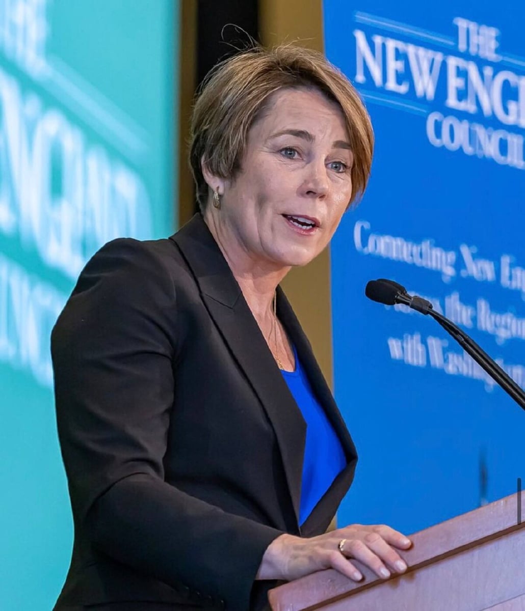 Governor Maura Healey speaking at a podium at a New England Council event.