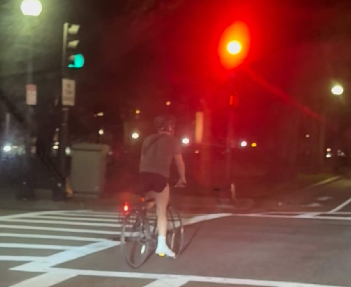 A cyclist blows through a red light in Boston's Back Bay — the kind of behavior critics say the city’s bike lobby refuses to address.