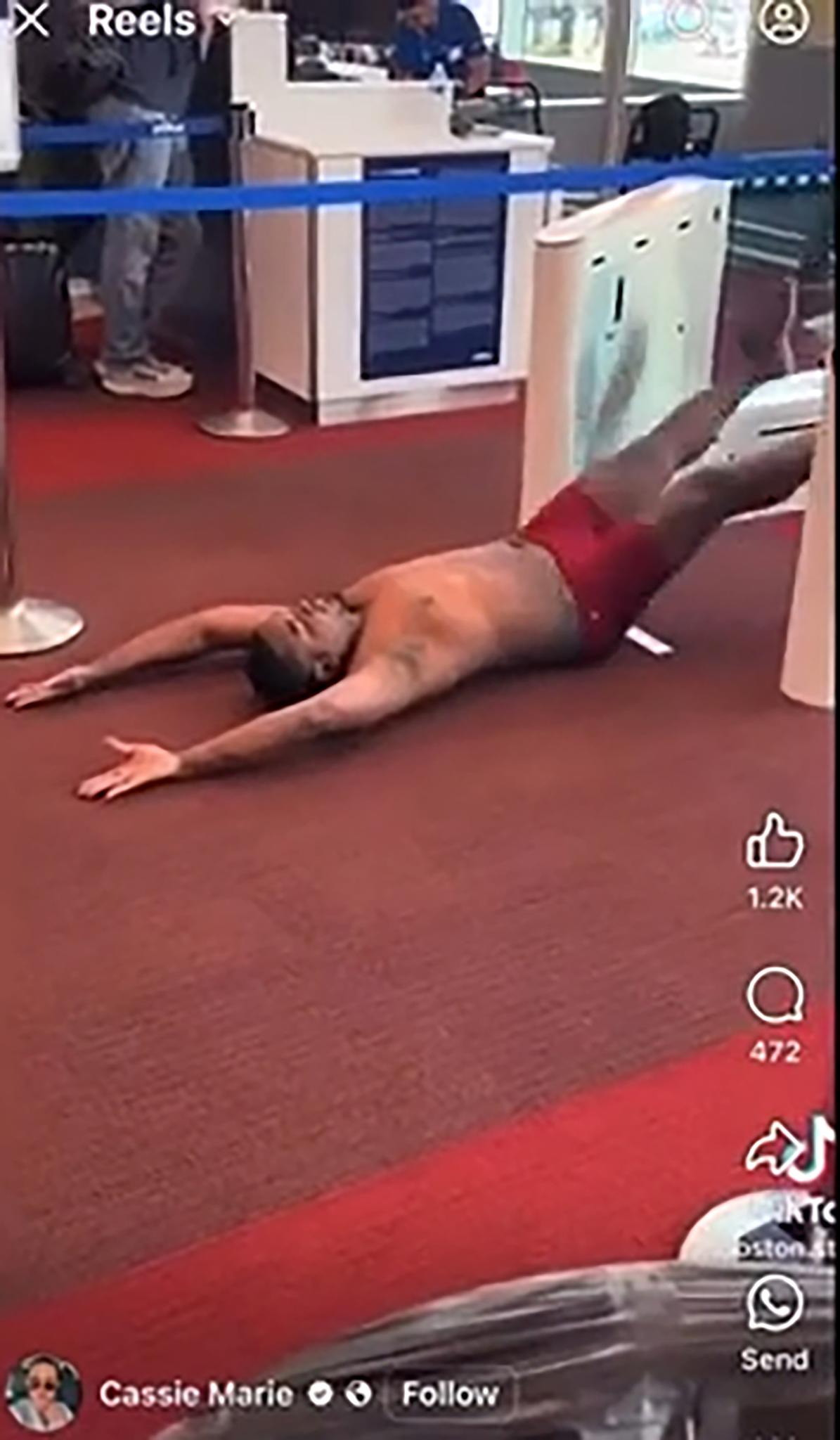 Logan freak show: Passenger in red briefs sprawls on the carpet as Boston’s chaos spills into the airport. (Instagram)