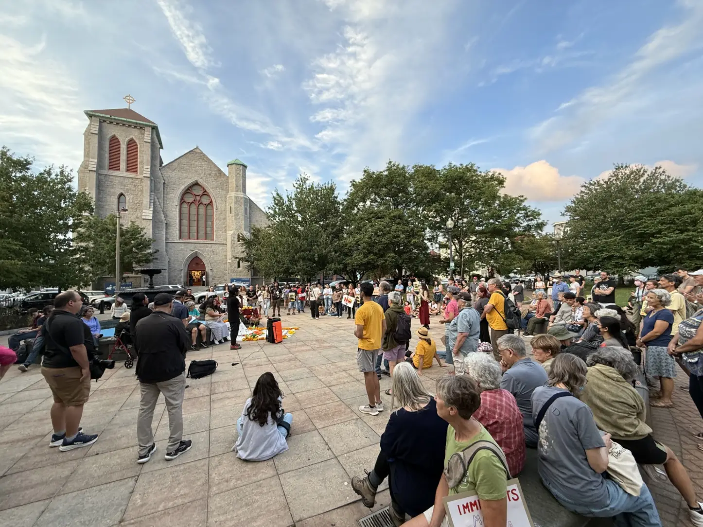 More than 100 people gathered outside a church in East Boston on Aug. 24, 2025, for a candlelight vigil demanding ICE release activists Carlos Chang Barrios and Catalina “Xochitl” Santiago. (Sarah Betancourt/GBH News)
