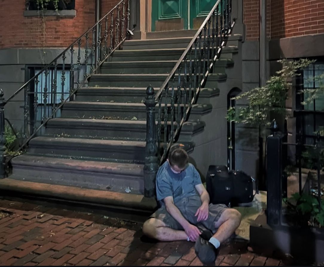 An addict slumped on the stoop of a million-dollar South End townhouse — neighbors say drugs and crime now spill onto once-prized streets. (Southendsos/Instagram)